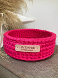 petite panière rose fuschia avec une étiquette handmade limited edition posée sur un banc