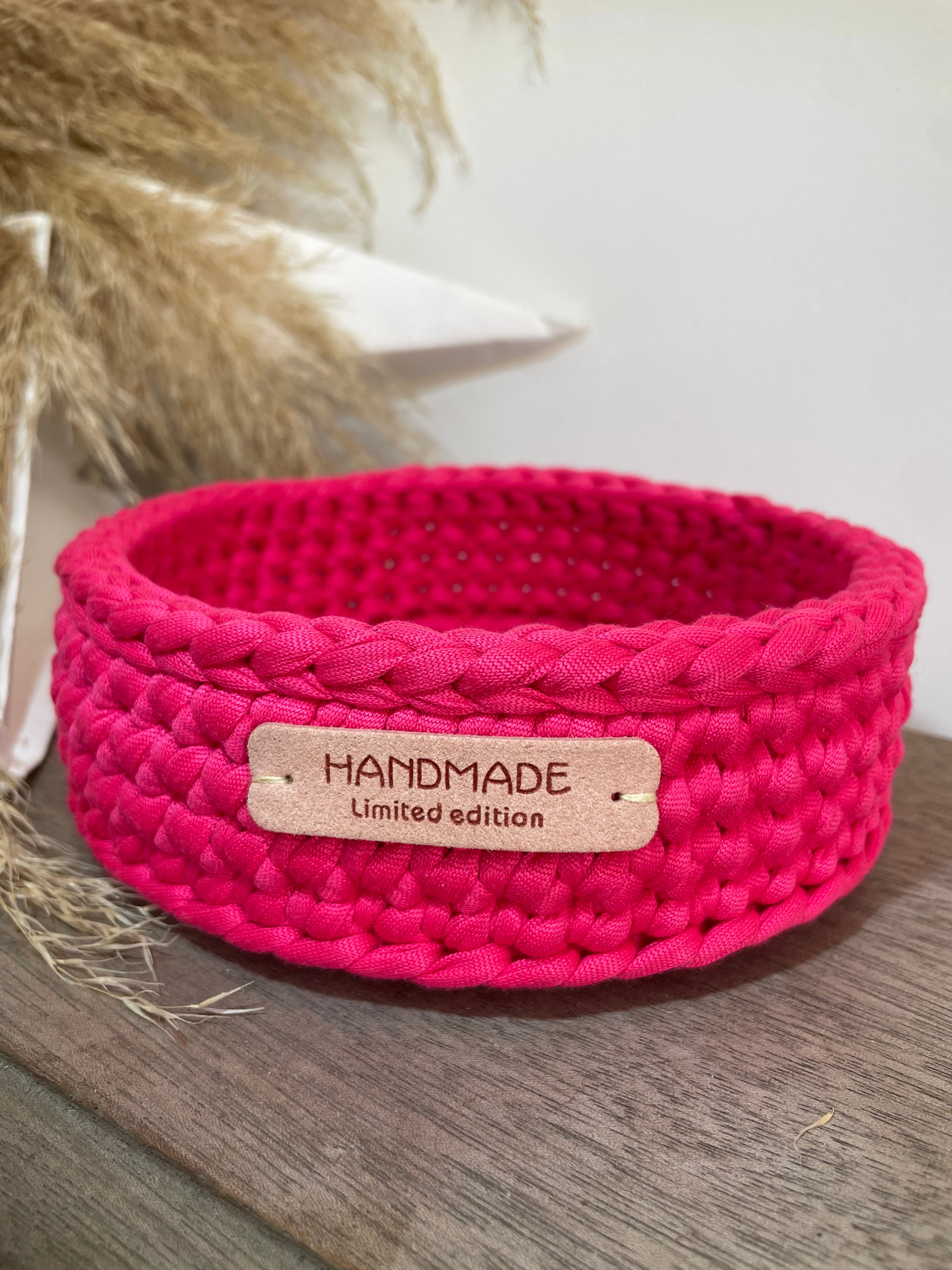 petite panière rose fuschia avec une étiquette handmade limited edition posée sur un banc