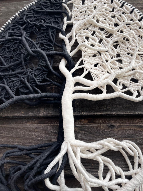 détails d'une création murale artisanale en technique macramé arbre de vie deux couleurs un coté noir un coté blanc avec les feuilles branches tronc et racines 