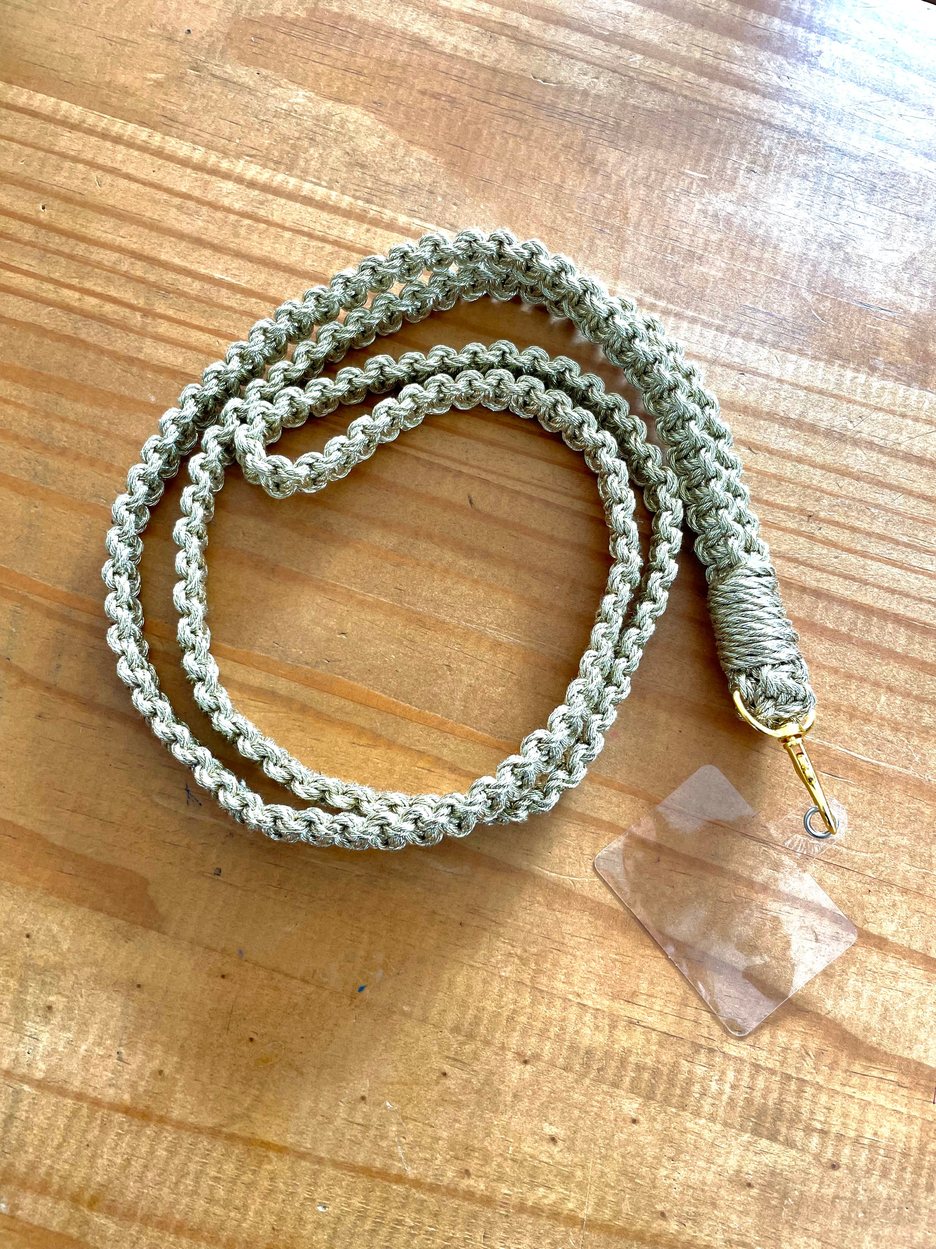 cordon de téléphone doré en macramé enroulé sur une table