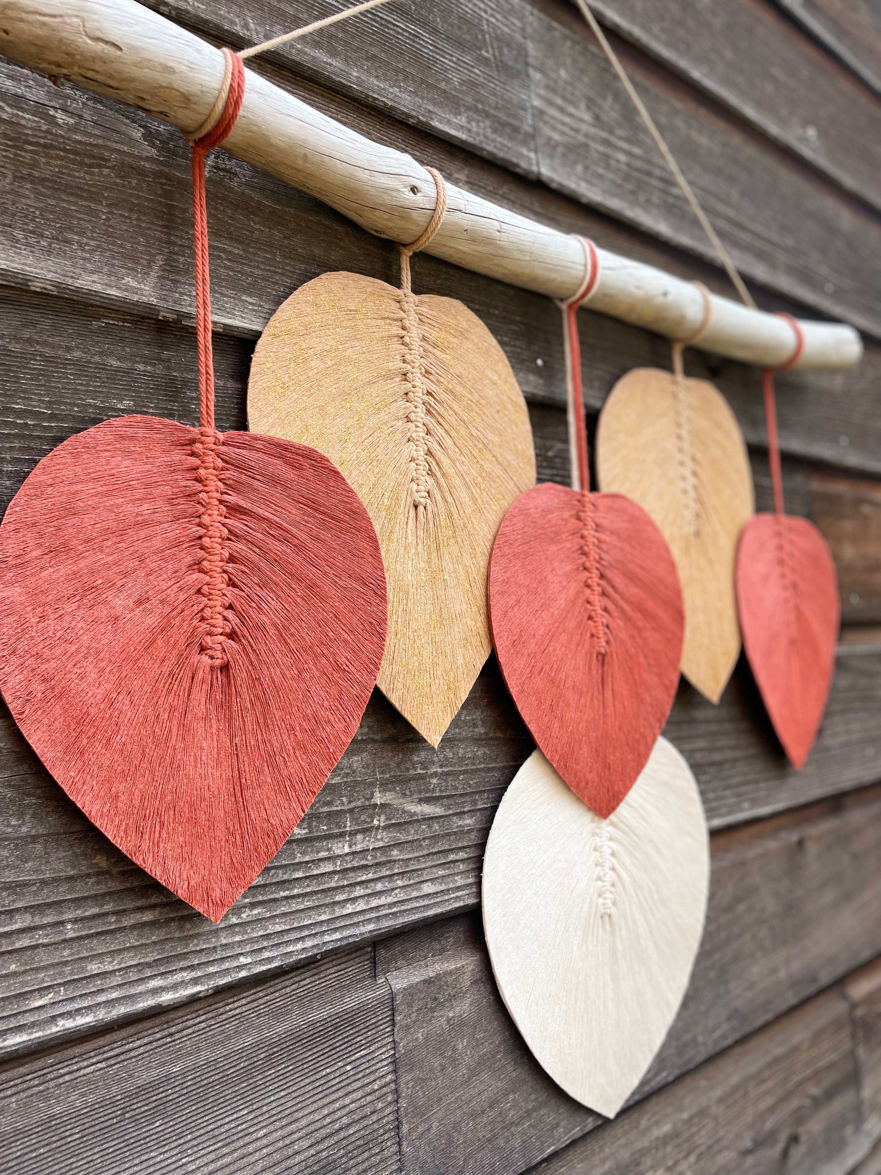 décoration murale artisanale base bois flotté avec des feuilles en coton stabilisées suspendues couleurs automnales blanc terracotta beige doré technique macramé