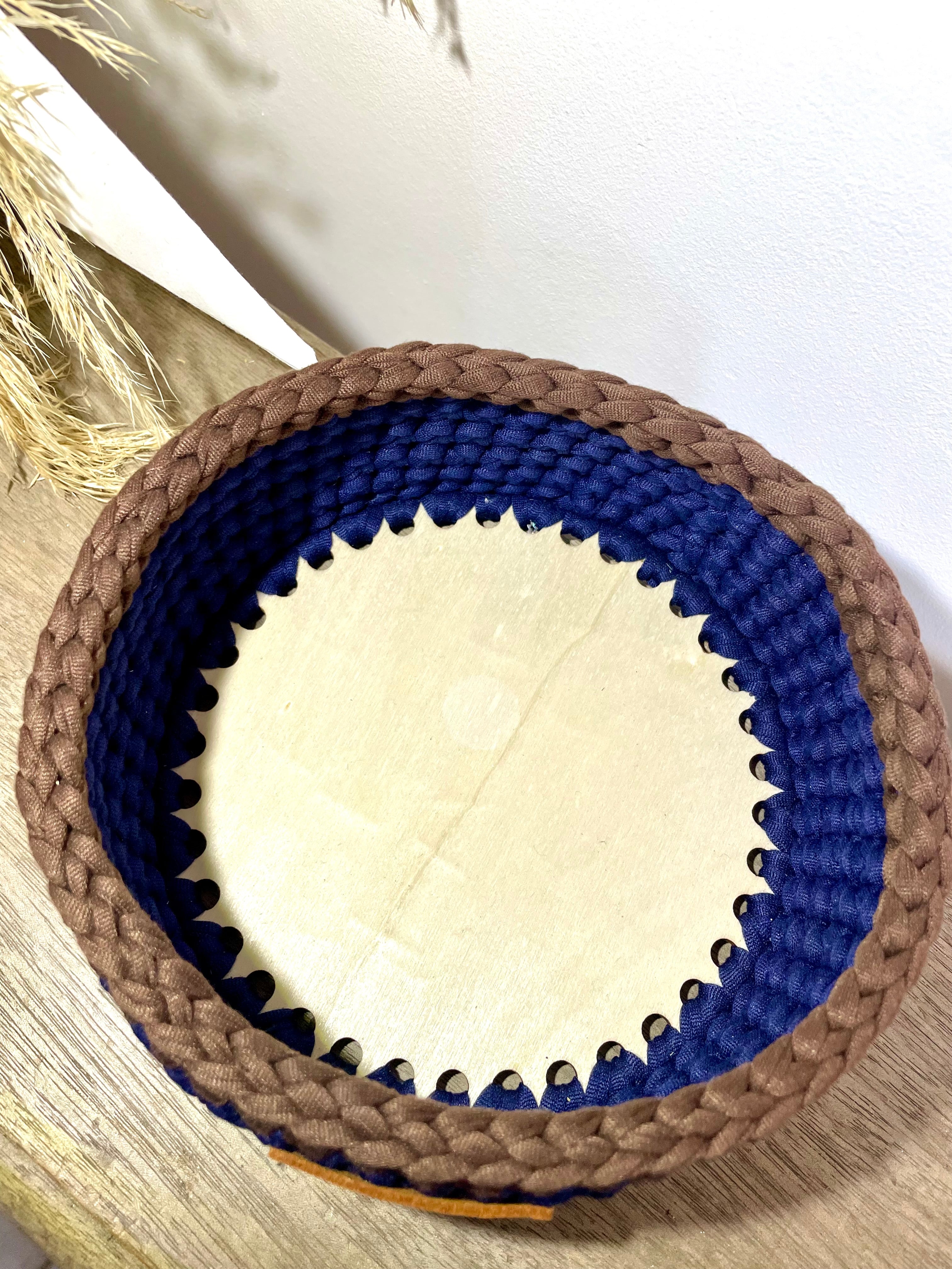 fond en bois d'une panière bleue et marron au crochet