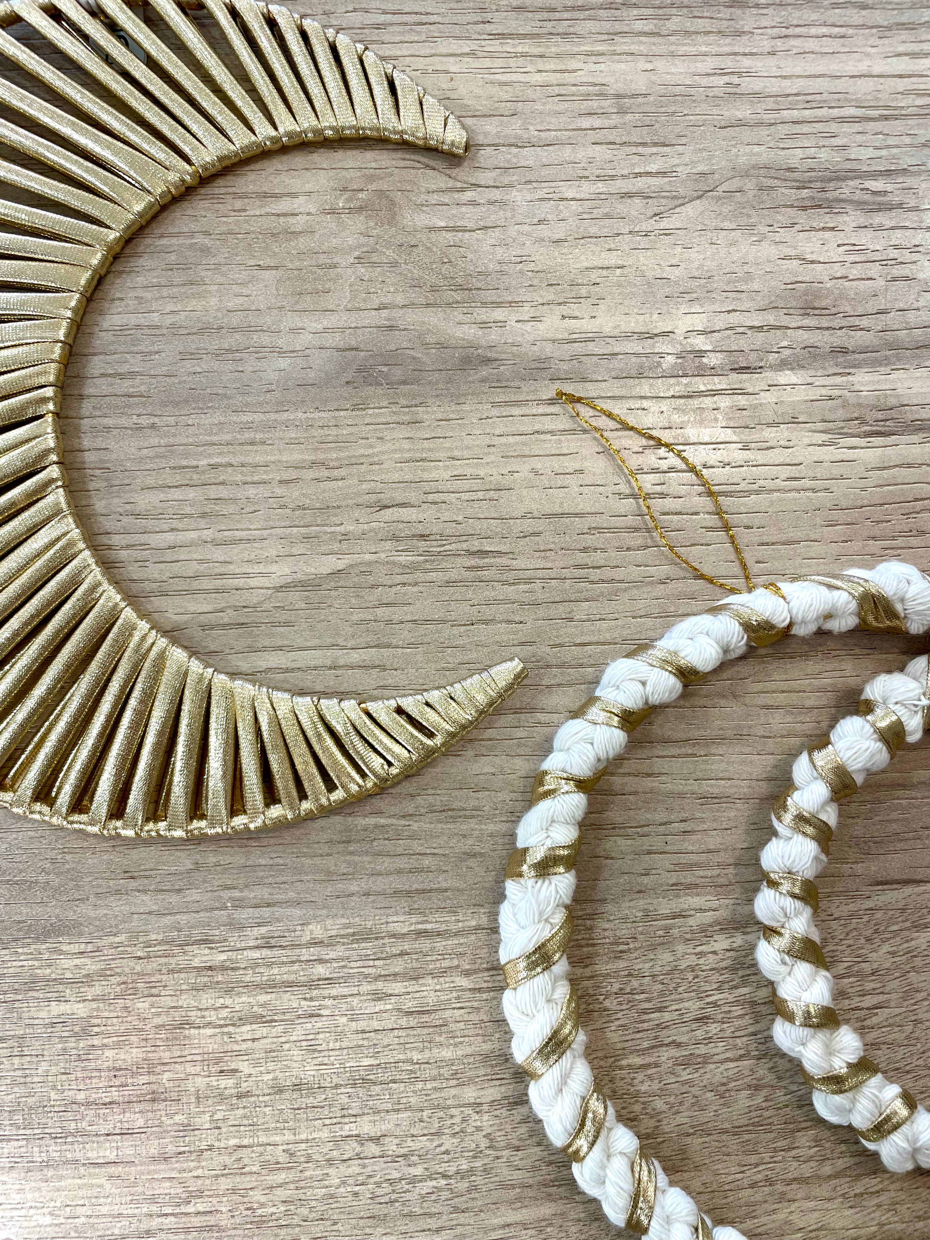 deux décorations en forme de lune vue de près fabrication artisanale avec la technique macramé de couleur blanche et dorée