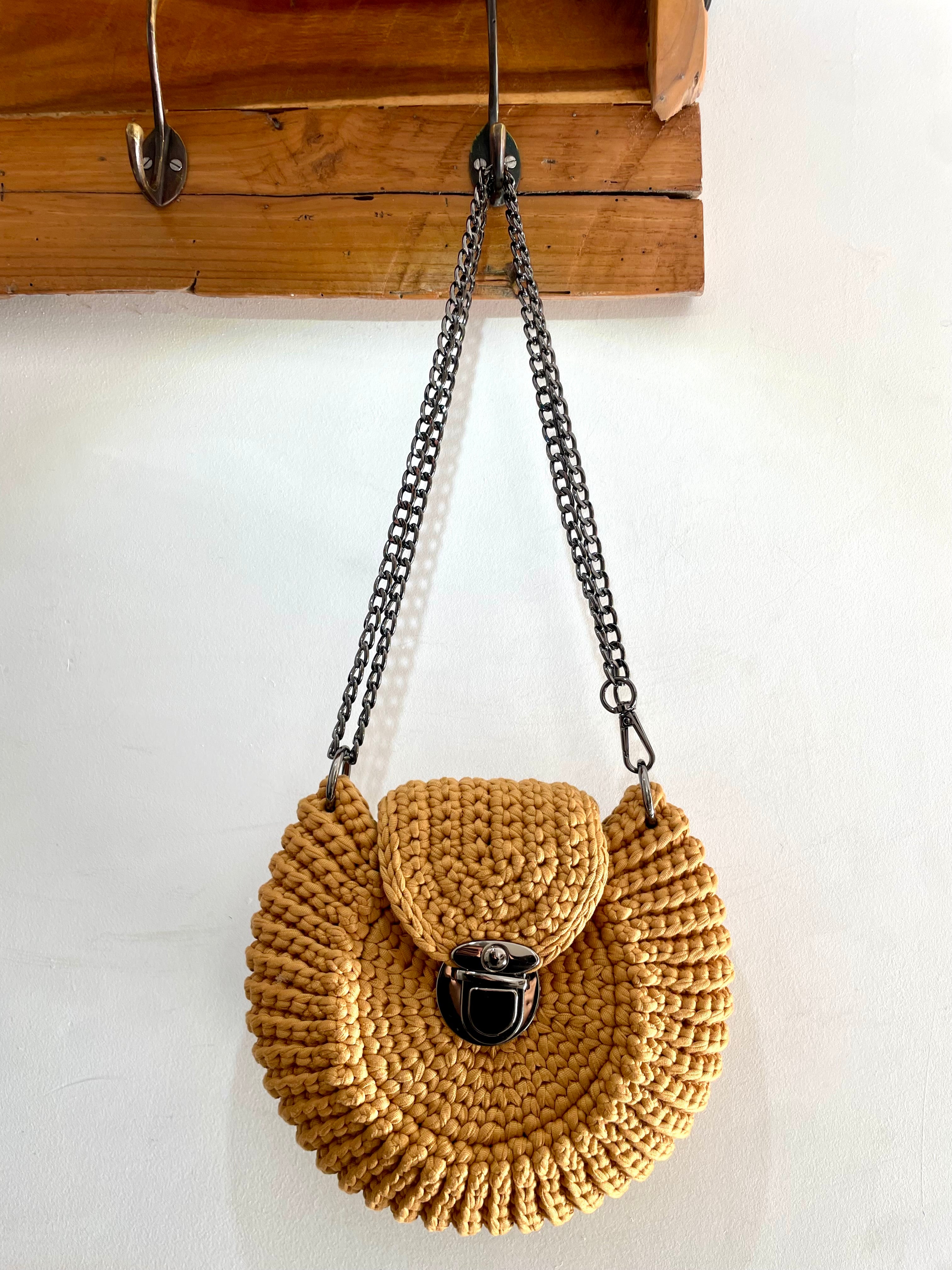 sac coquillage caramel avec fermoir noir métallisé tressage au crochet suspendu à une patère en bois