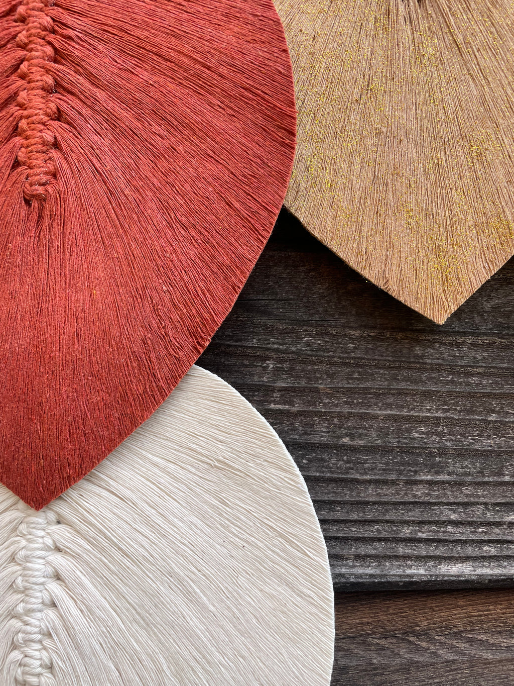 zoom sur trois feuilles réalisées en technique macramé stabilisé fabrication artisanale à la main couleur terracotta blanc et beige pailleté doré
