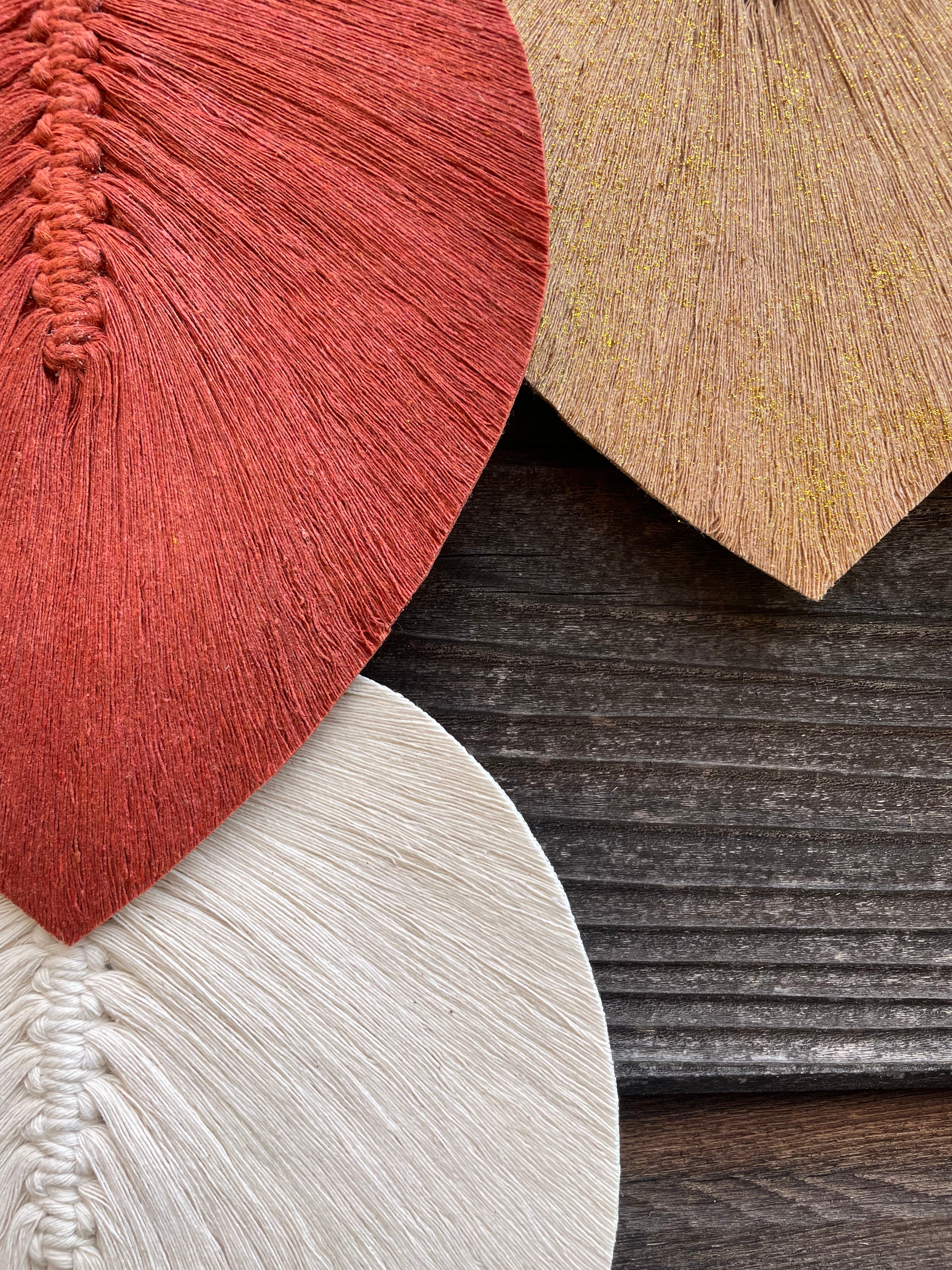 zoom sur trois feuilles réalisées en technique macramé stabilisé fabrication artisanale à la main couleur terracotta blanc et beige pailleté doré