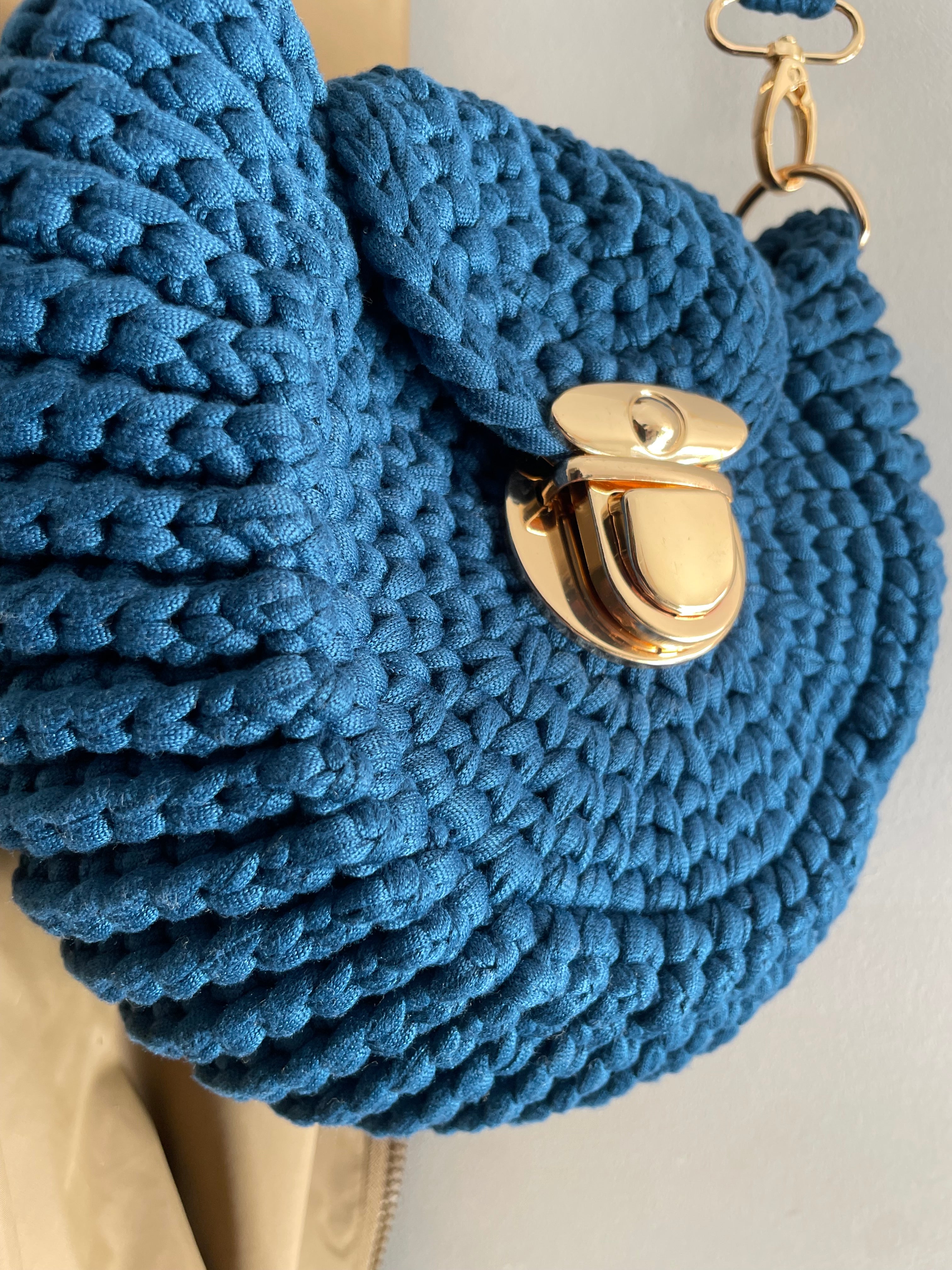 zoom sur un sac forme coquillage bleu avec fermeture dorée